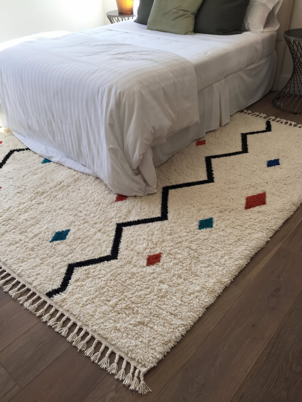 Ivory Azilal rug with a black zigzag and colorful accents in a bedroom