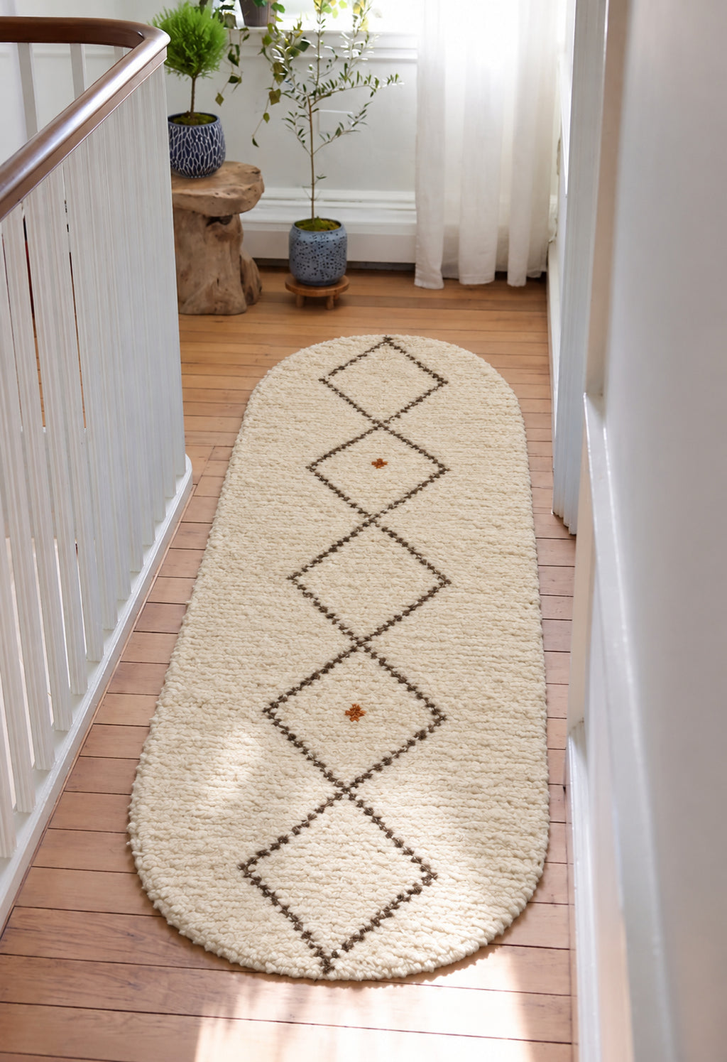 Ivory Beni Ourain oval rug with a charcoal diamond chain in a styled interior