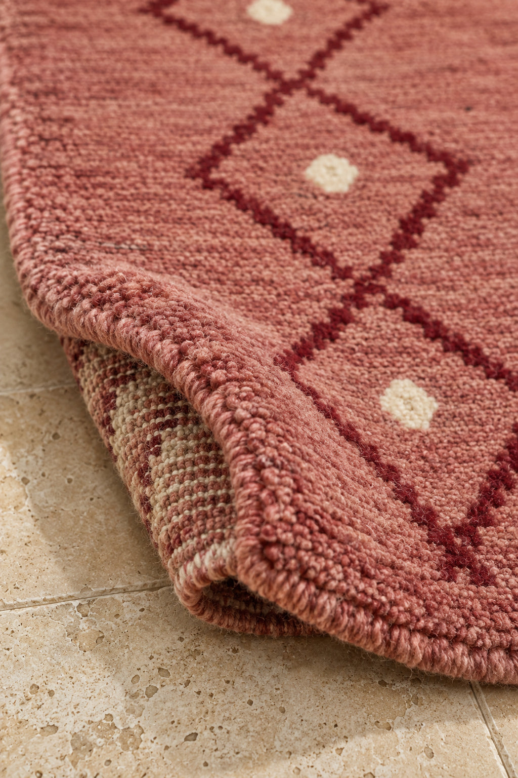 Thick pile of Beni Ourain oval rug model TF-09 on a folded corner