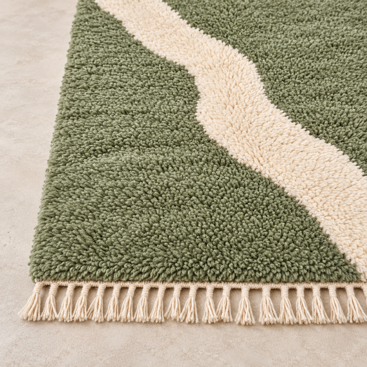 Détail du bord et des franges du tapis Mrirt vert sauge